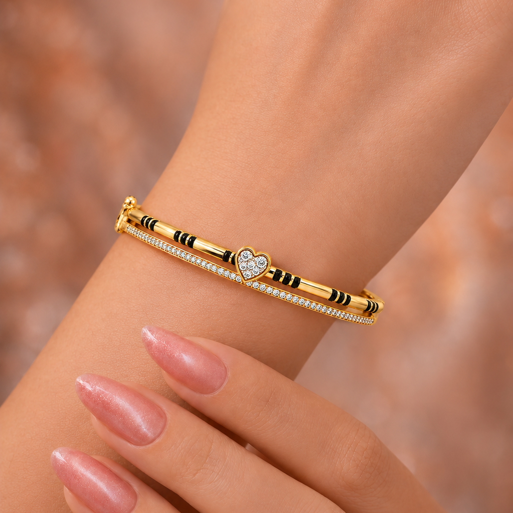 Redefine your bridal collection with the Beloved Heart Mangalsutra Bracelet. Designed for the woman who honors her traditions while embracing a modern, sophisticated aesthetic, this piece seamlessly transitions from daily wear to celebratory events. It serves as a beautiful update to the classic mangalsutra, replacing the traditional chain with a sleek, gold-and-diamond bangle silhouette that sparkles with every movement.