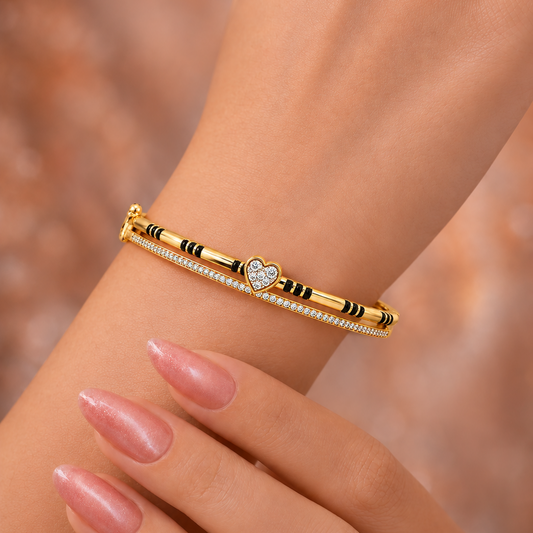 Redefine your bridal collection with the Beloved Heart Mangalsutra Bracelet. Designed for the woman who honors her traditions while embracing a modern, sophisticated aesthetic, this piece seamlessly transitions from daily wear to celebratory events. It serves as a beautiful update to the classic mangalsutra, replacing the traditional chain with a sleek, gold-and-diamond bangle silhouette that sparkles with every movement.