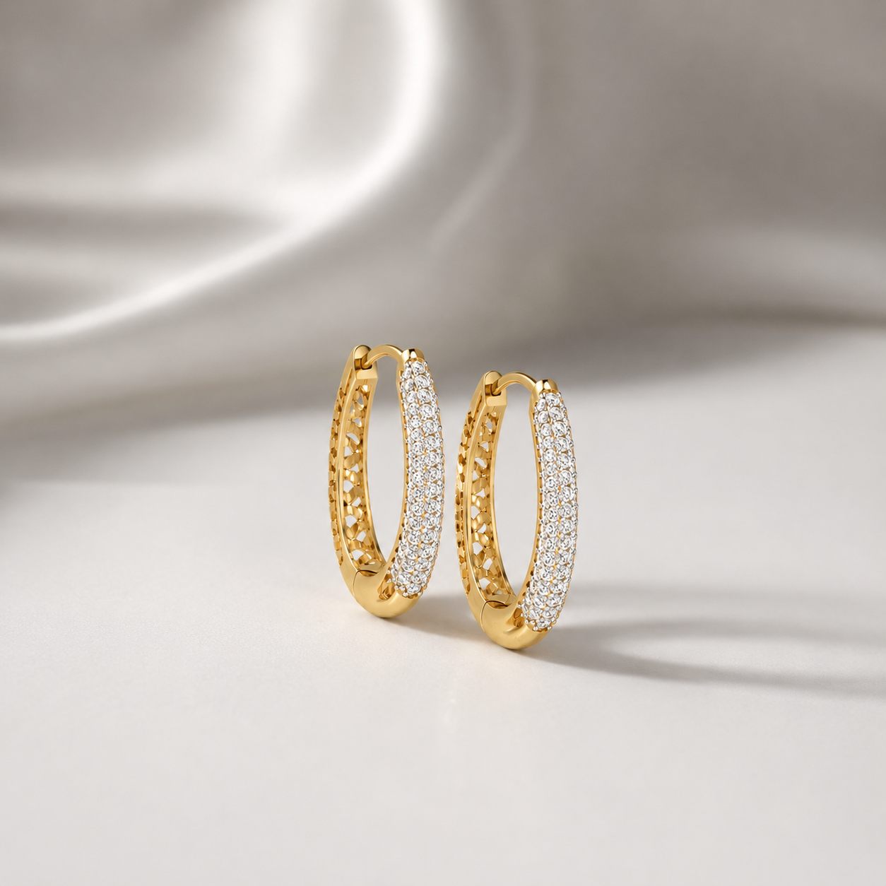 Discover The Luminary Pavé Arch Diamond Hoop Earrings, featuring an expansive oval design set with 156 brilliant diamonds and exquisite cutout craftsmanship. Available in 14K or 18K gold, these artisan-made hoops are the ultimate accessory for modern, high-fashion elegance. 