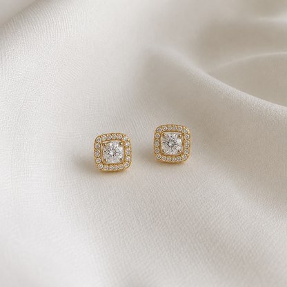 Discover The Radiant Square Halo Studs, featuring a brilliant 5.1mm round-cut center stone framed by a square halo of 36 diamonds. Crafted in 14K or 18K gold, these elegant, artisan-made studs are designed for timeless appeal. 