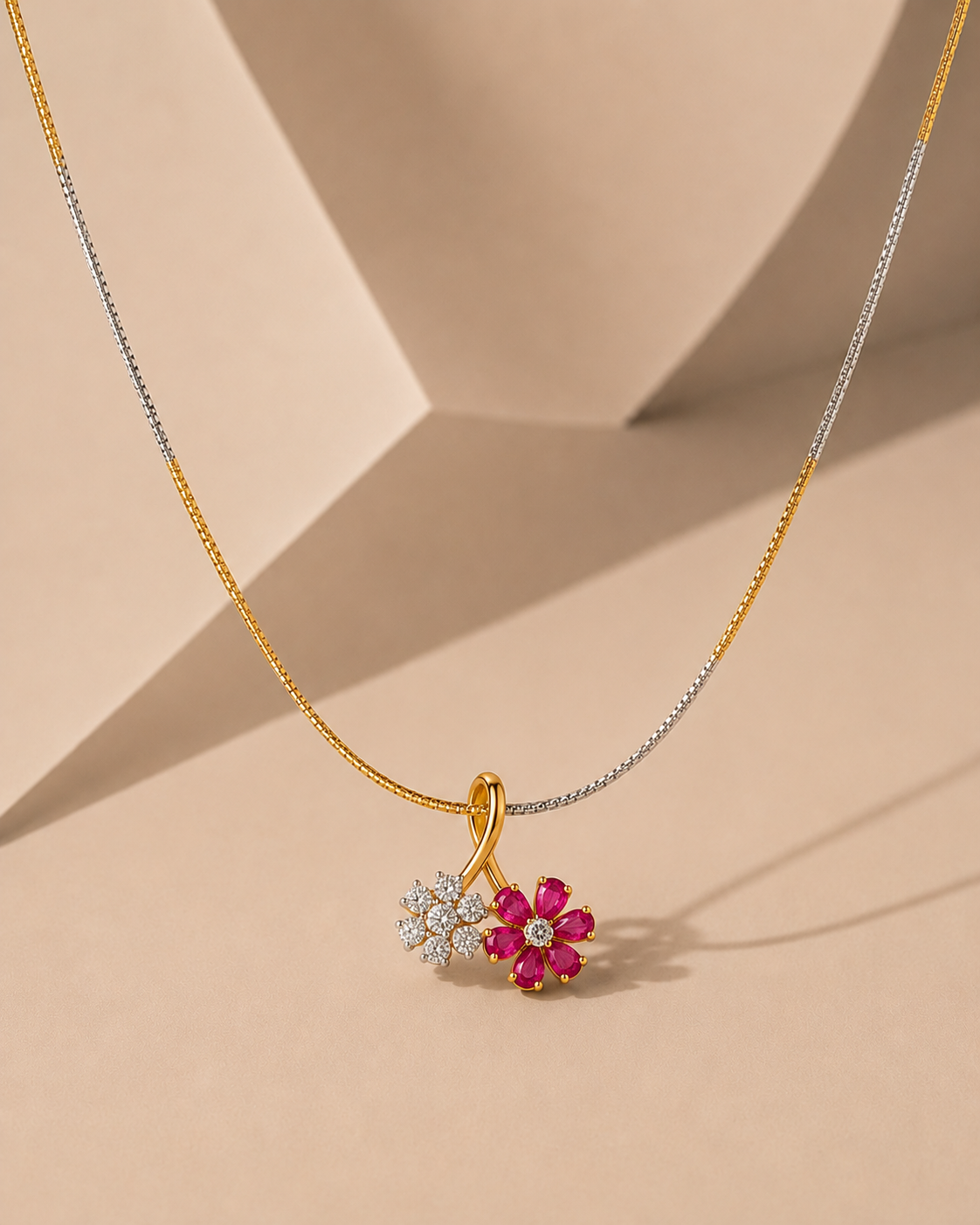 A yellow gold dual flower pendant necklace featuring one flower made of sparkling white diamonds and another made of vibrant rani colored stones