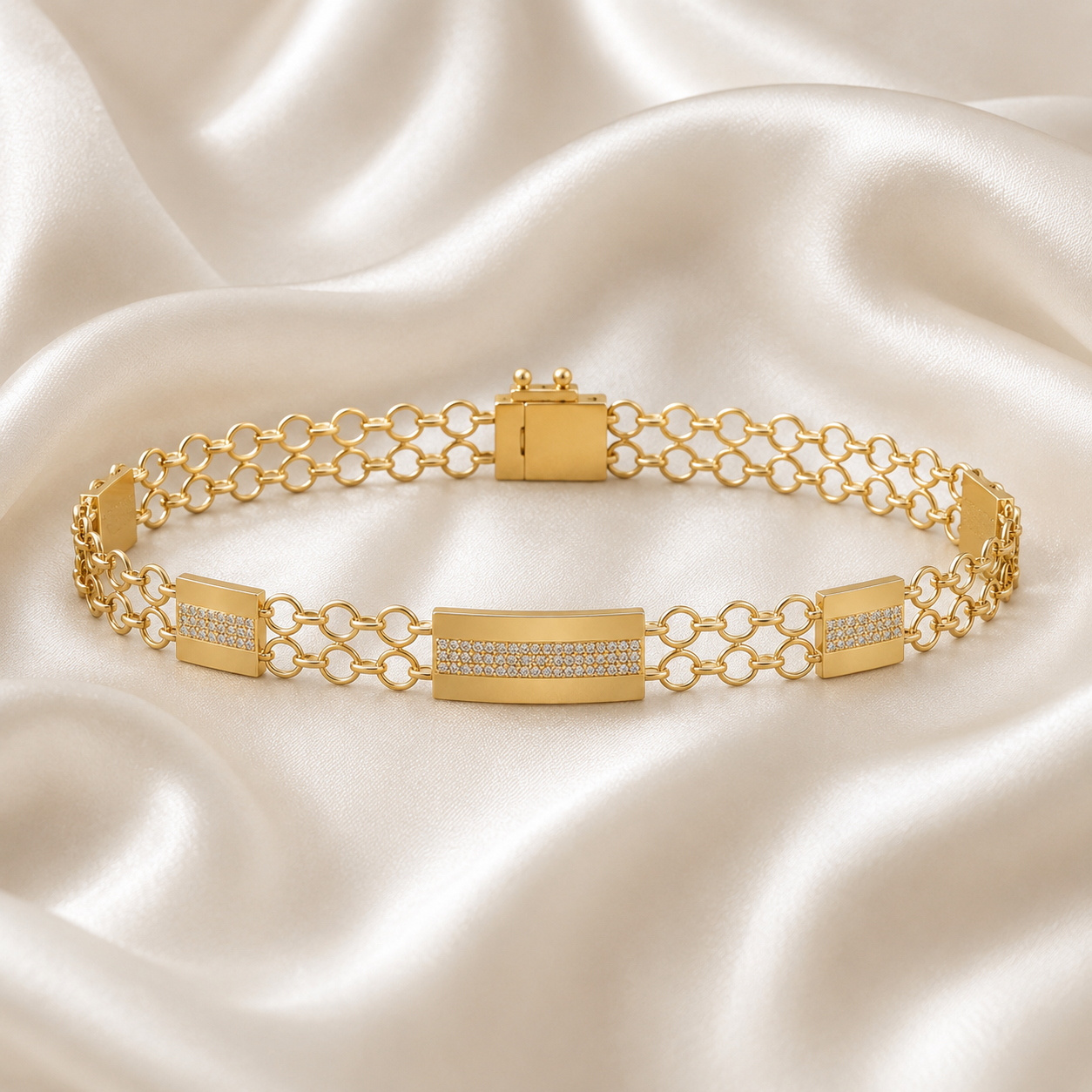 "A yellow gold bracelet featuring a central rectangular bar accented with small diamonds, connected by a double row of open circle chain links on a white silk background