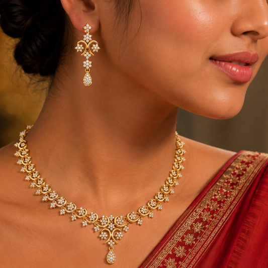 Gold and diamond necklace set featuring delicate floral diamond clusters with a pear-shaped central drop and matching earrings.