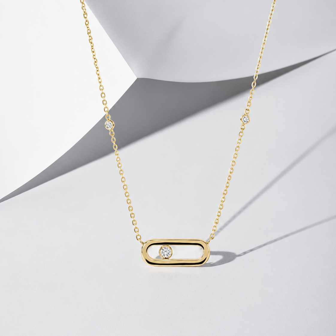 A yellow gold necklace featuring a horizontal hollow bar pendant with a single round diamond sitting inside the center frame.