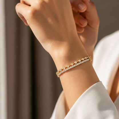 A yellow gold tennis bracelet featuring two connected rows of small round diamonds layered on top of each other.