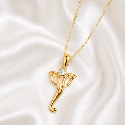 A yellow gold pendant necklace featuring a simple minimalist silhouette of Lord Ganesha with a single round diamond sparkling at the top.