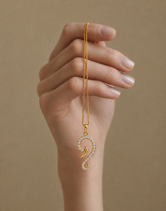 A yellow gold Vakratunda Ganesha trunk pendant necklace lined with brilliant diamonds, representing a modern spiritual protection charm.