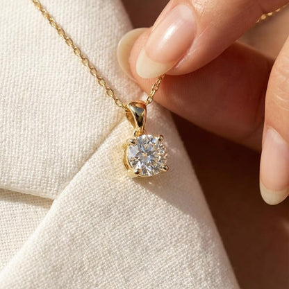 A yellow gold chain necklace featuring a large round brilliant-cut diamond solitaire pendant secured in a timeless four-prong setting.