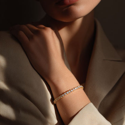 A yellow gold tennis bracelet featuring a single row of continuous round-cut diamonds, displayed as a full circle against a solid white background.