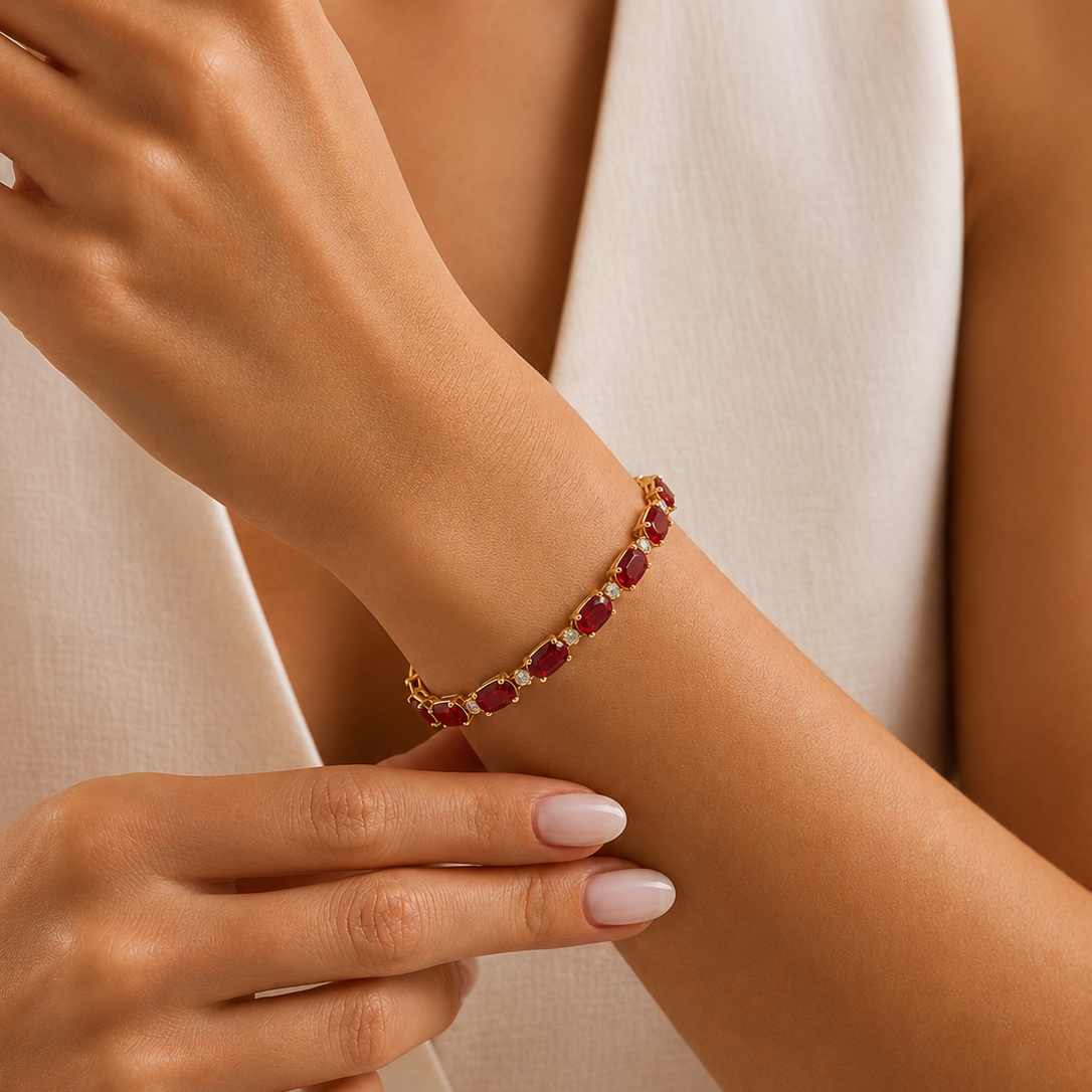 A yellow gold link bracelet, featuring oval-cut red rubies alternating with tiny round white diamonds.