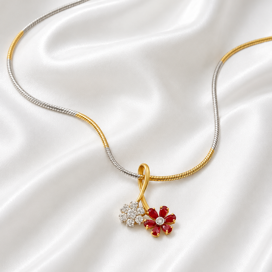 A yellow gold dual flower pendant necklace featuring one flower made of sparkling white diamonds and another made of rich red rubies.
