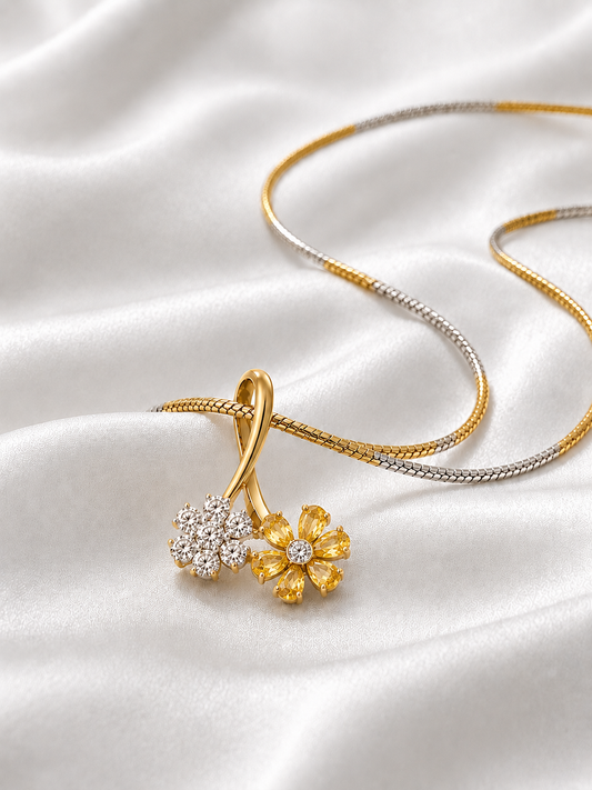 A yellow gold dual flower pendant necklace featuring one flower made of sparkling white diamonds and another made of bright yellow gemstones.