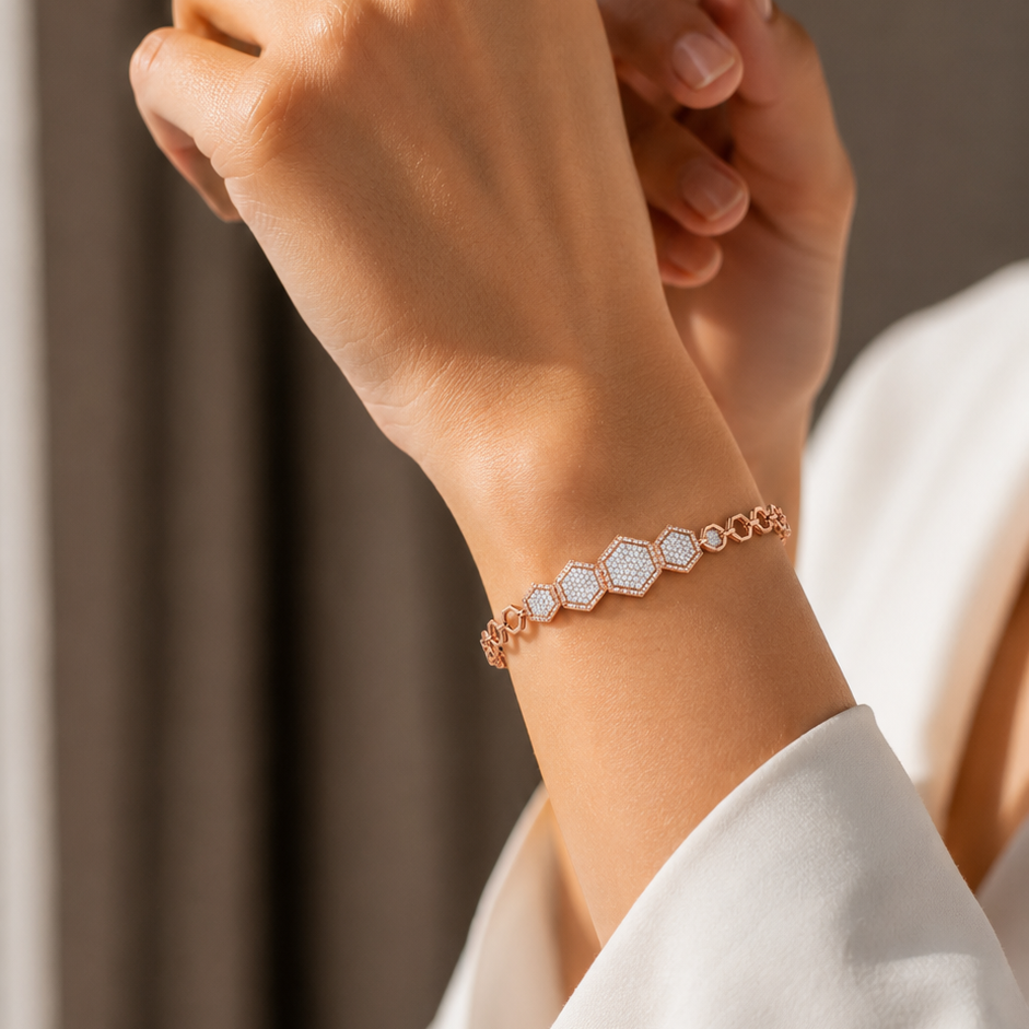A rose gold bracelet featuring a central cluster of five graduated, diamond-paved hexagon links connected to an open geometric chain.