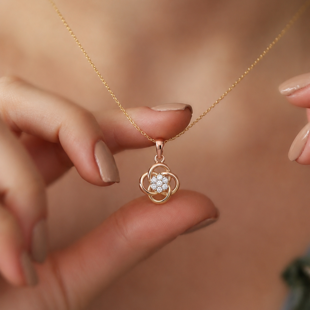 A delicate rose gold pendant featuring four overlapping, open-loop petals arranged in a stylized clover motif, centering a clustered floral arrangement of seven prong-set round white diamonds.